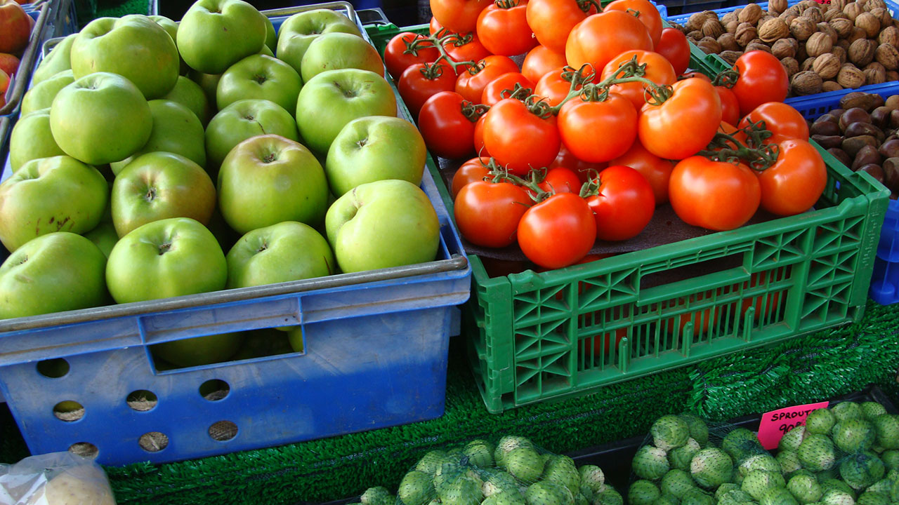 Fresh apples and tomatoes displayed in market crates